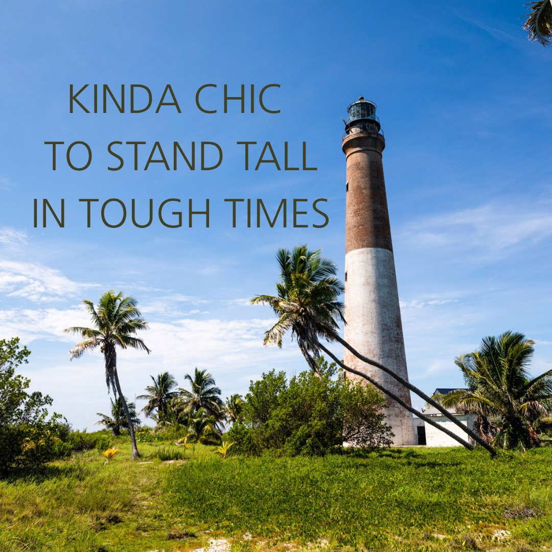 Storm damaged palm trees lean almost horizontally in front of the Loggerhead Lighthouse next to the words "kinda chic to stand tall in tough times."